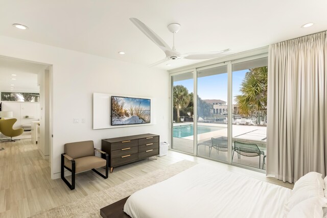 bedroom with light wood-type flooring, access to exterior, expansive windows, and recessed lighting