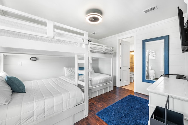 bedroom with hardwood / wood-style flooring and connected bathroom