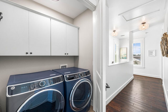 washroom with cabinets, hookup for a washing machine, washing machine and clothes dryer, and dark hardwood / wood-style floors