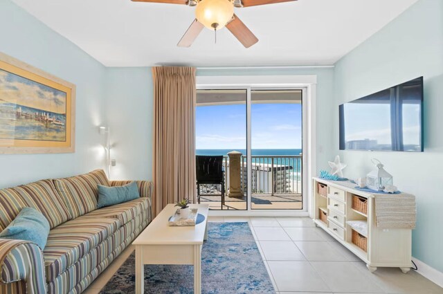 tiled living room with a water view and ceiling fan