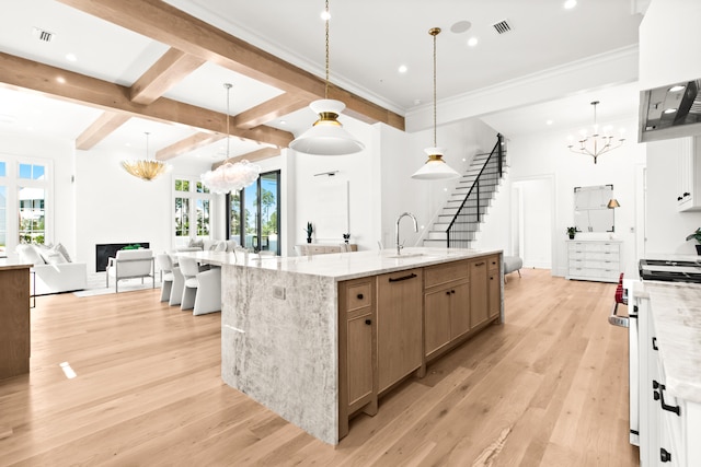 kitchen featuring light stone counters, light hardwood / wood-style flooring, pendant lighting, and plenty of natural light