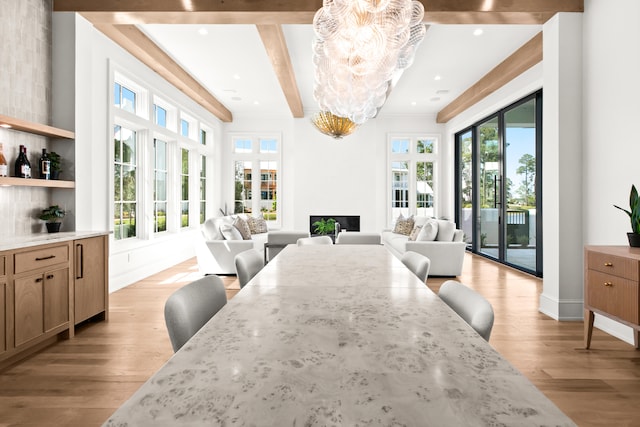 dining area with plenty of natural light, light hardwood / wood-style floors, and beam ceiling