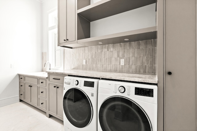 clothes washing area featuring independent washer and dryer, cabinets, and light tile floors