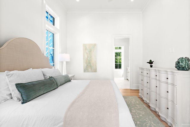 bedroom with light hardwood / wood-style floors and ornamental molding