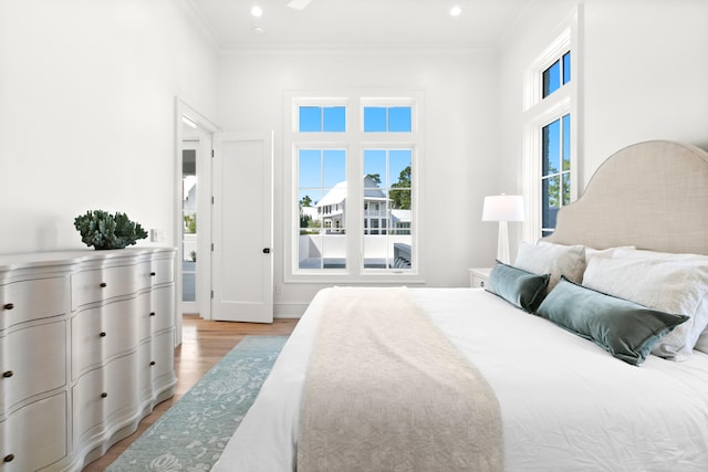 bedroom featuring ornamental molding and light wood-type flooring