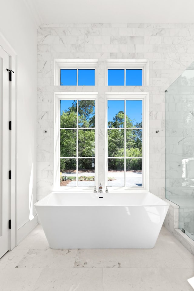 bathroom with a healthy amount of sunlight, tile walls, and tile flooring