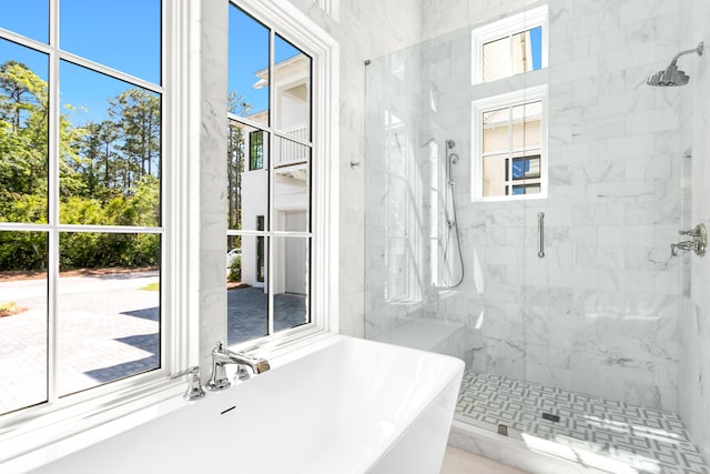 bathroom featuring shower with separate bathtub