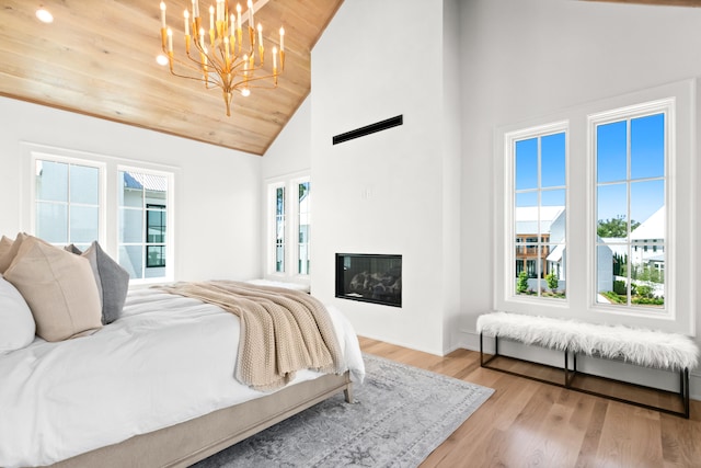 bedroom with wooden ceiling, light hardwood / wood-style floors, high vaulted ceiling, and a notable chandelier