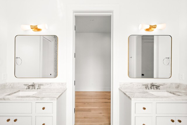 bathroom with hardwood / wood-style flooring, large vanity, and double sink