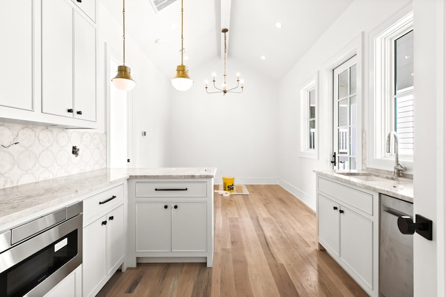 kitchen with white cabinets, lofted ceiling, light hardwood / wood-style flooring, and tasteful backsplash