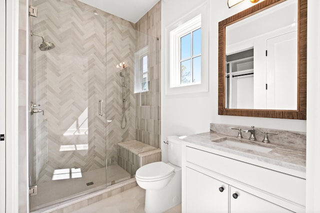 bathroom featuring tile flooring, walk in shower, vanity, and toilet