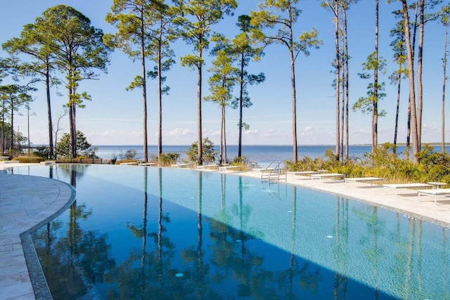 view of swimming pool with a water view and a diving board