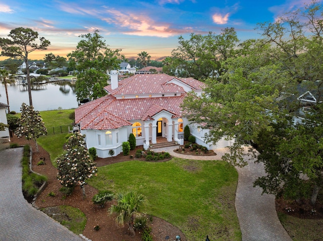 view of front of property featuring a water view and a lawn