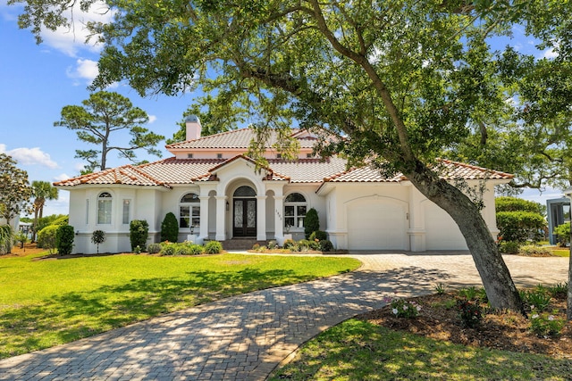 mediterranean / spanish house featuring a front yard and a garage