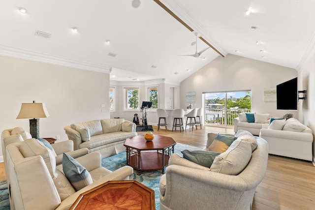 living room with a healthy amount of sunlight, light hardwood / wood-style flooring, lofted ceiling with beams, and crown molding