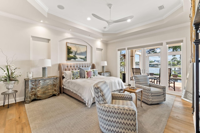 bedroom with access to outside, crown molding, hardwood / wood-style flooring, and a tray ceiling