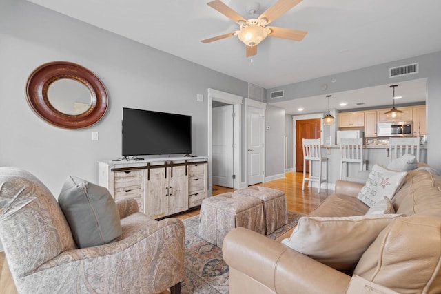 living room featuring ceiling fan and light wood-type flooring