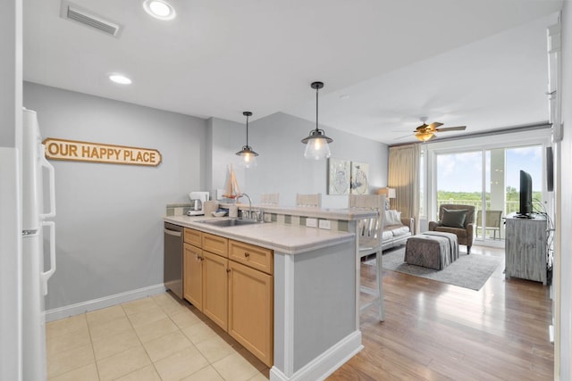 kitchen featuring pendant lighting, light tile flooring, sink, dishwasher, and ceiling fan