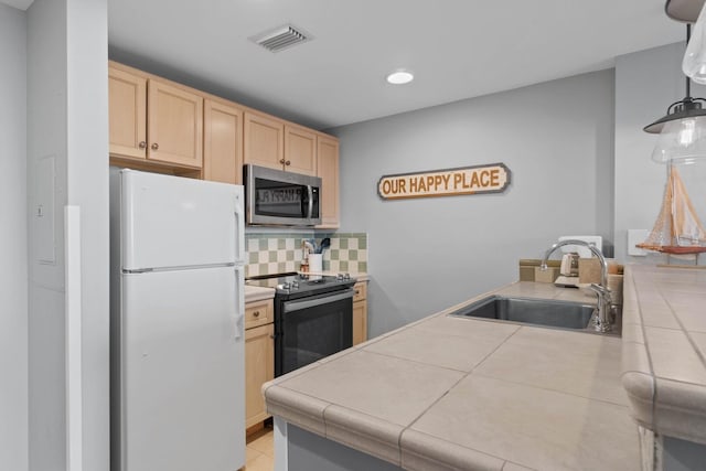 kitchen featuring black range with electric stovetop, white refrigerator, backsplash, sink, and tile countertops