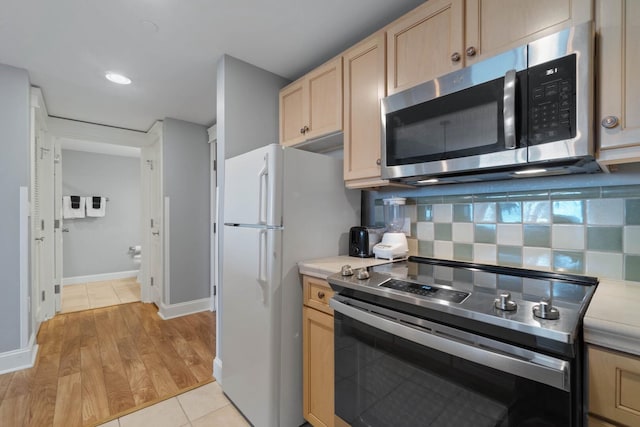 kitchen featuring backsplash, stainless steel appliances, light tile floors, and light brown cabinetry