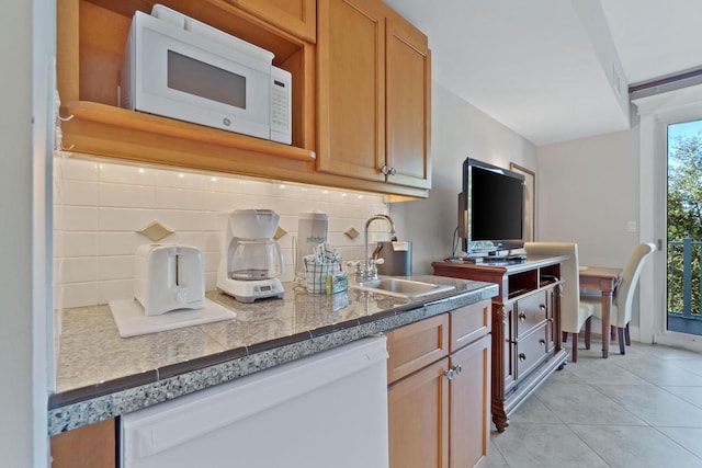 kitchen featuring sink, white appliances, light tile flooring, and backsplash