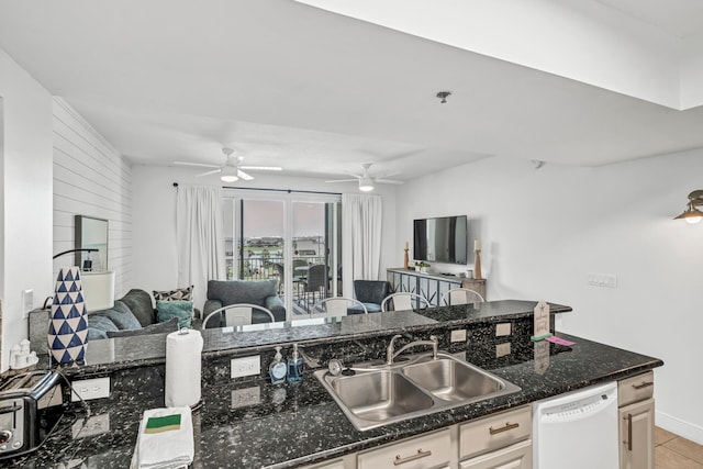 kitchen featuring white dishwasher, sink, dark stone countertops, white cabinets, and light tile patterned flooring