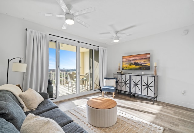 living room with ceiling fan and light wood-type flooring