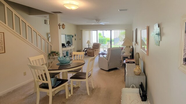 carpeted dining room with ceiling fan