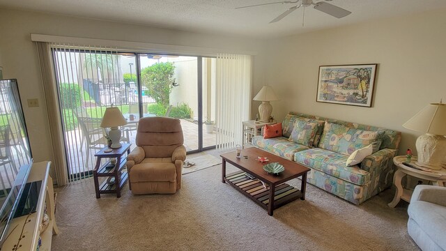 living room featuring ceiling fan, carpet flooring, and a textured ceiling