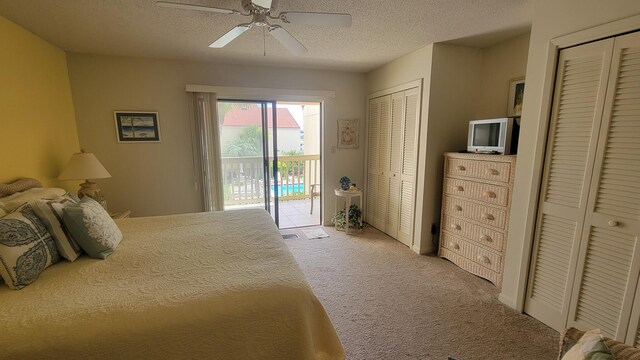 bedroom featuring access to exterior, a textured ceiling, ceiling fan, and carpet floors