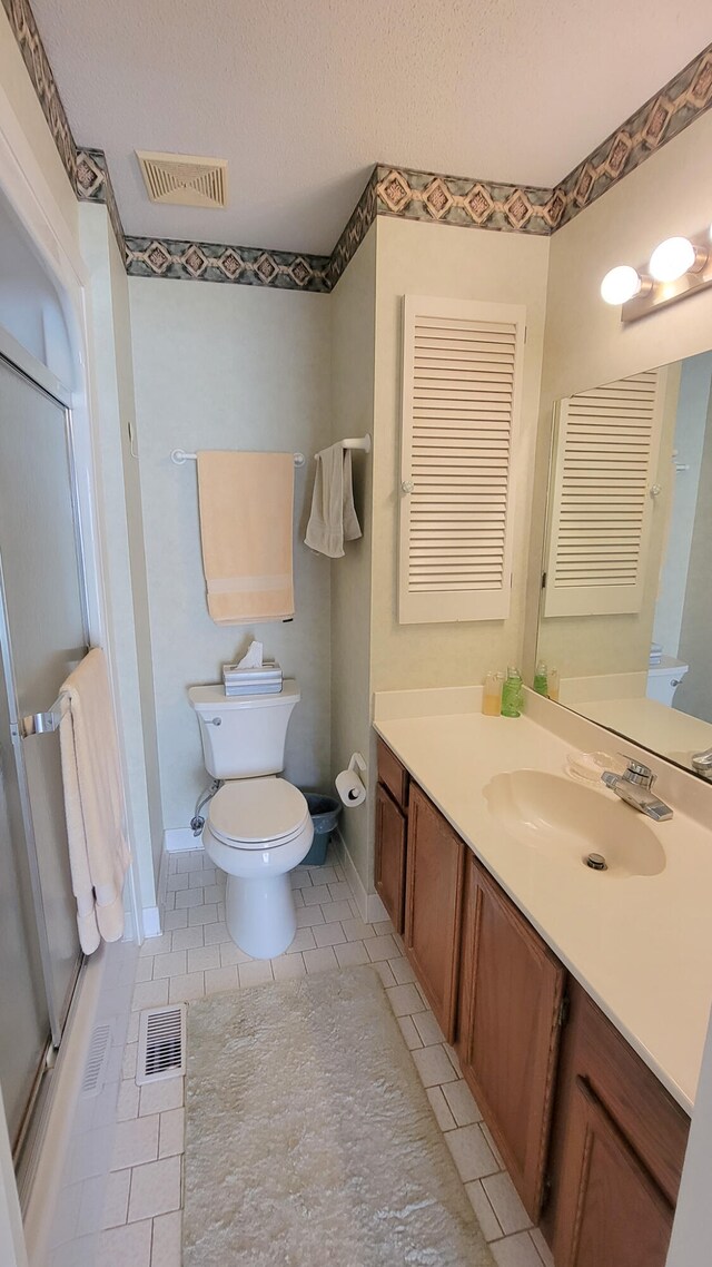 bathroom with toilet, tile flooring, and large vanity