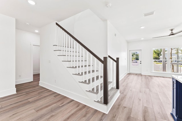 stairs with ceiling fan and hardwood / wood-style floors