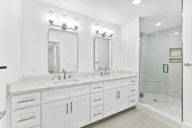 bathroom with a shower with shower door, tile patterned floors, and vanity