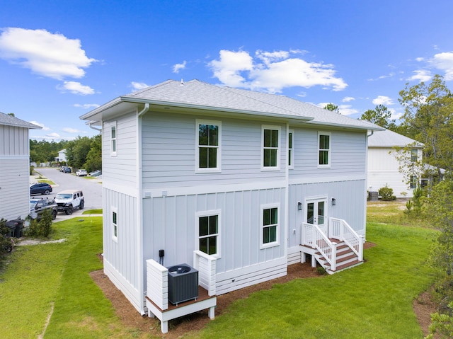 rear view of house with central air condition unit, french doors, and a yard