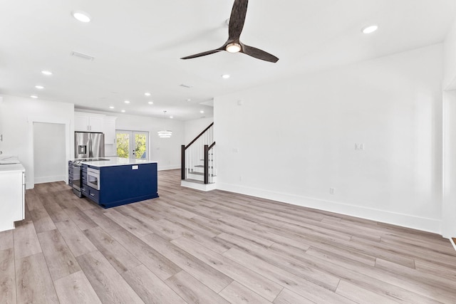 unfurnished living room with ceiling fan, light hardwood / wood-style flooring, and french doors