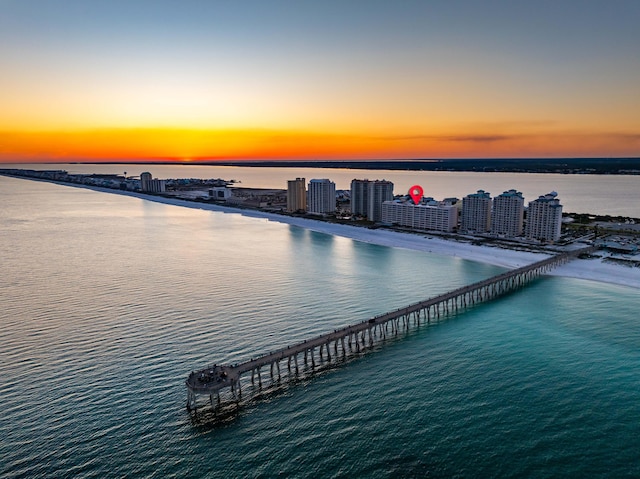 aerial view at dusk featuring a water view