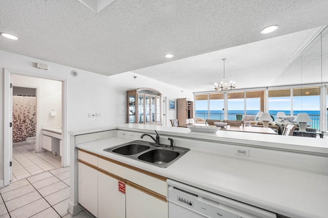 kitchen with dishwashing machine, white cabinetry, light tile patterned floors, sink, and an inviting chandelier