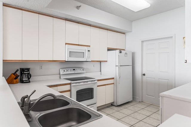 kitchen featuring sink, white cabinetry, white appliances, and light tile patterned floors