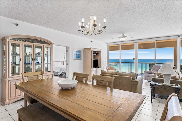 dining space featuring a textured ceiling, ceiling fan with notable chandelier, and light tile patterned floors