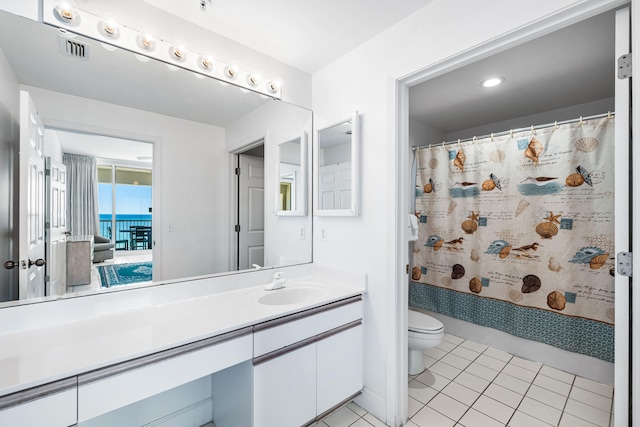 bathroom with toilet, vanity, a shower with curtain, and tile patterned floors