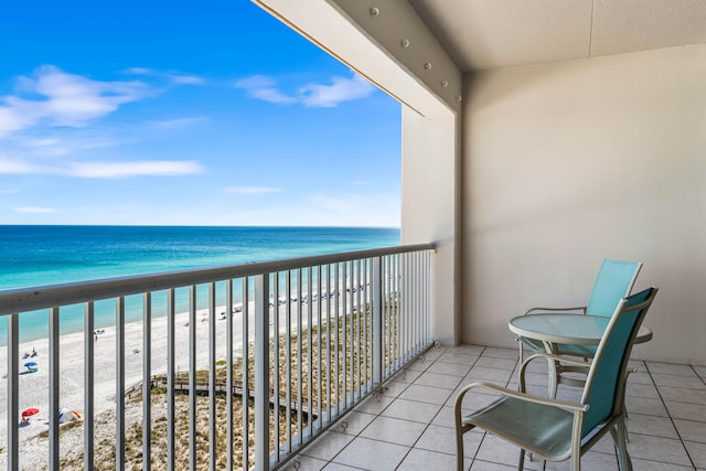 balcony with a water view and a view of the beach