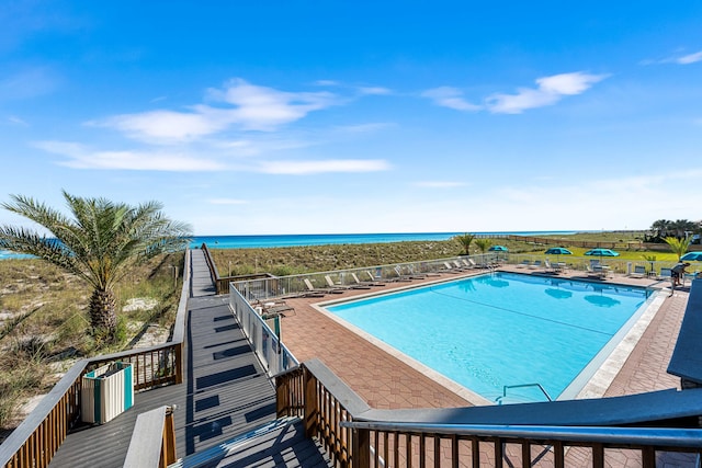 view of swimming pool featuring a patio area and a water view