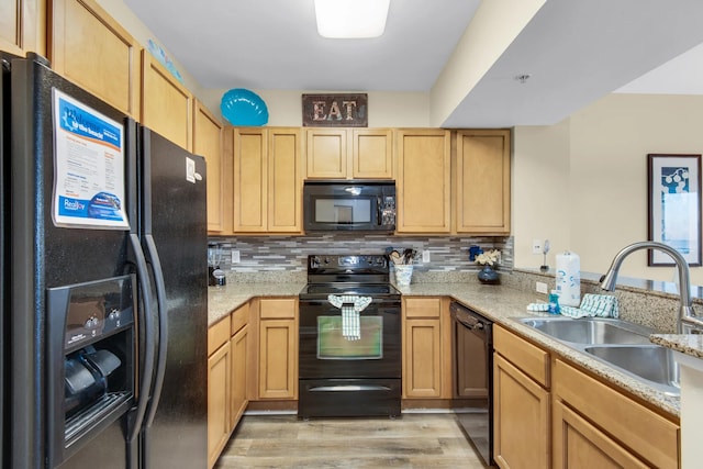 kitchen with sink, light hardwood / wood-style floors, backsplash, and black appliances