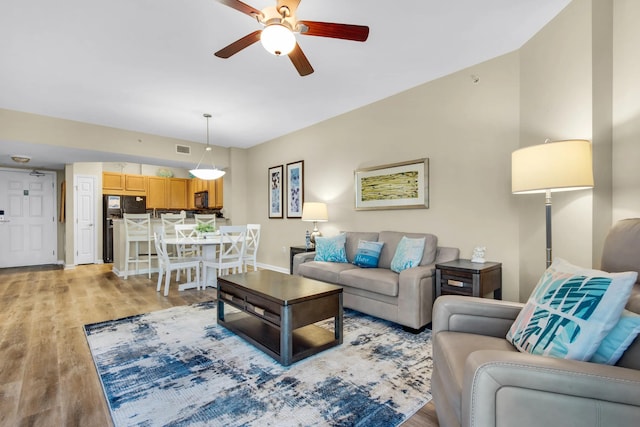 living room featuring light hardwood / wood-style floors and ceiling fan