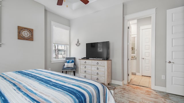 bedroom with light hardwood / wood-style flooring, ceiling fan, and ensuite bathroom