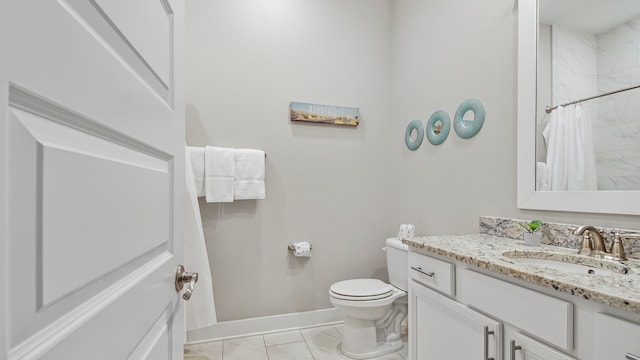 bathroom with vanity, tile floors, and toilet