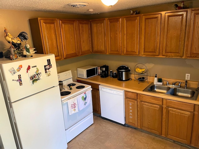 kitchen featuring a textured ceiling, sink, and white appliances