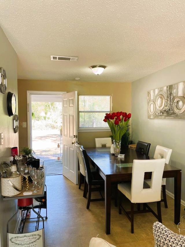 dining space featuring a textured ceiling and a wealth of natural light