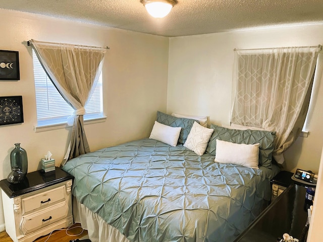 bedroom with a textured ceiling and hardwood / wood-style floors