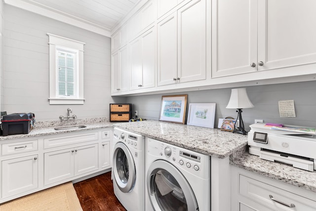 clothes washing area featuring ornamental molding, dark hardwood / wood-style flooring, washing machine and dryer, and sink